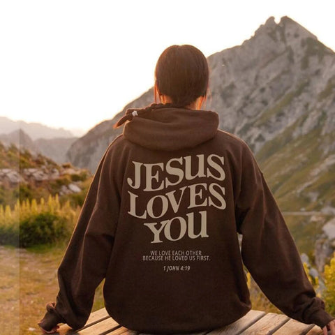 Woman wearing brown jesus loves you hoodie at mountains